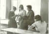Перемена после урока. Т. Шорохова и Е. Бубнова (стоят) что-то обсуждают с Андрейчевой (математика). На переднем плане справа сидит С. Шеремет.
